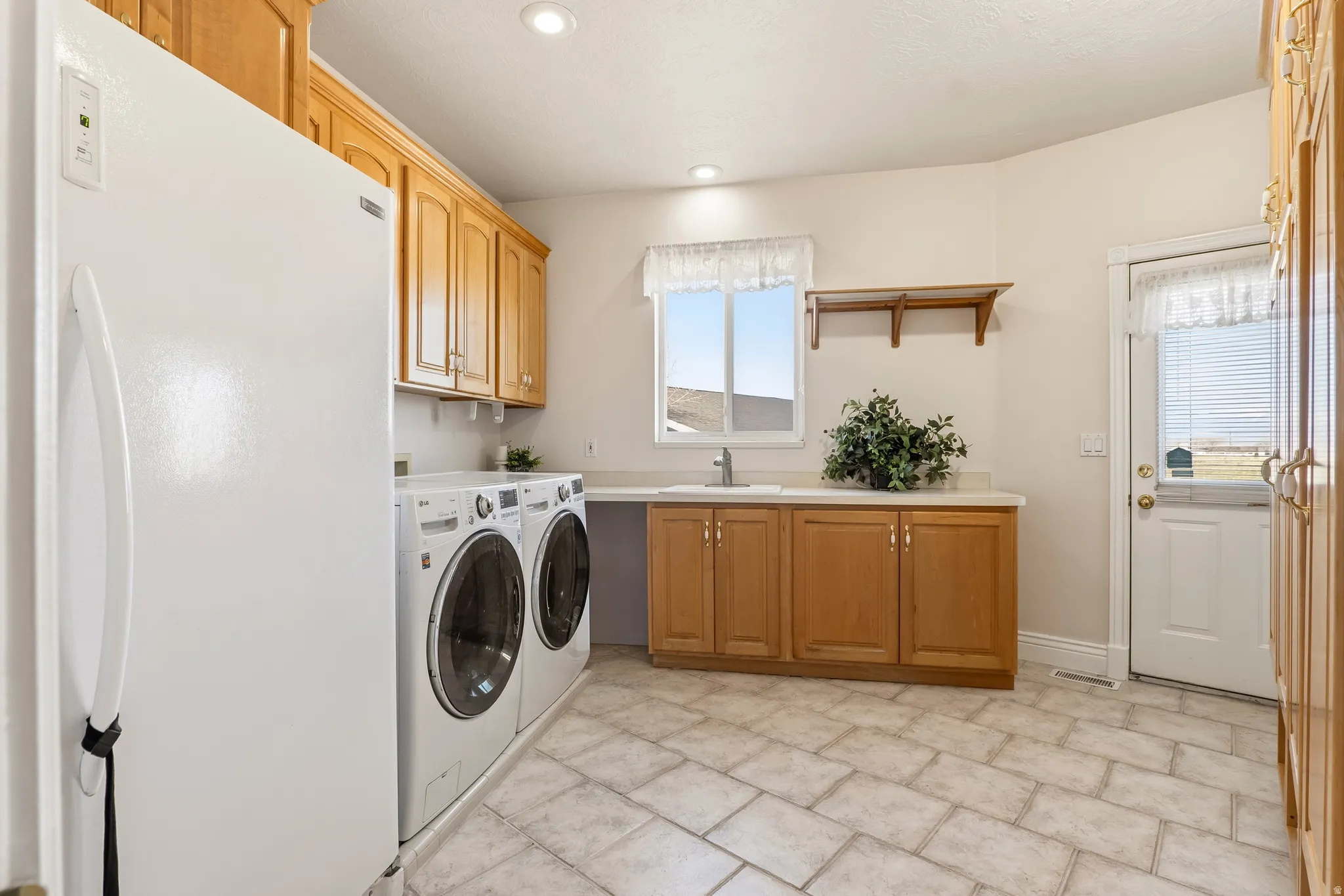 Laundry area featuring cabinet space, independent washer and dryer, and recessed lighting