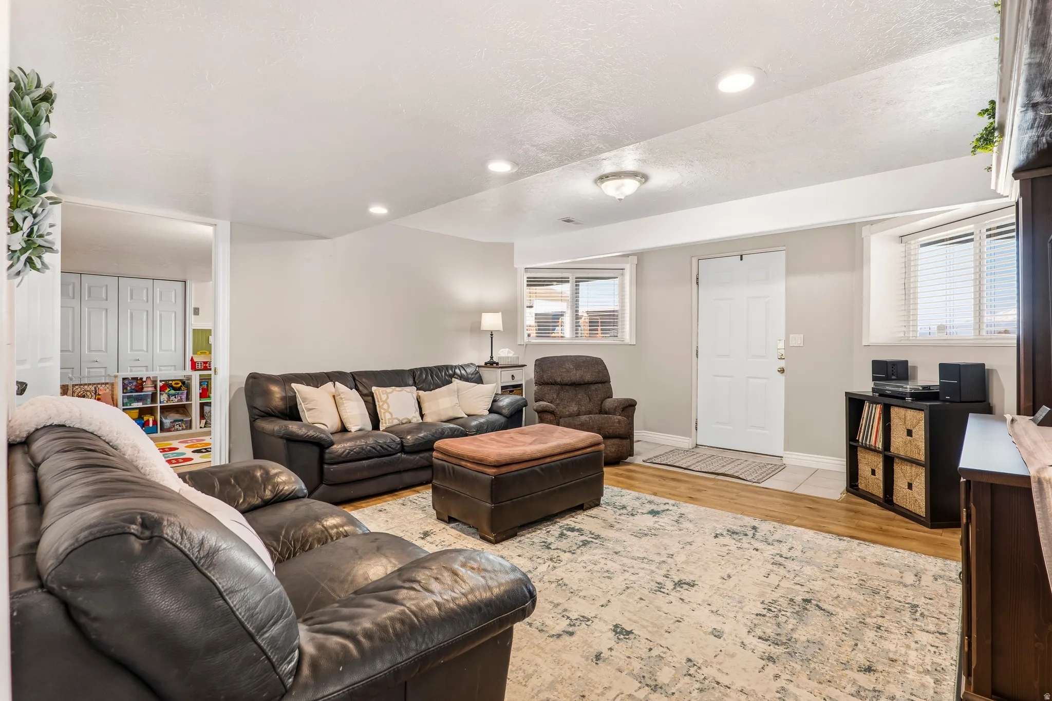 Living area with light wood-style flooring, recessed lighting, and a textured ceiling