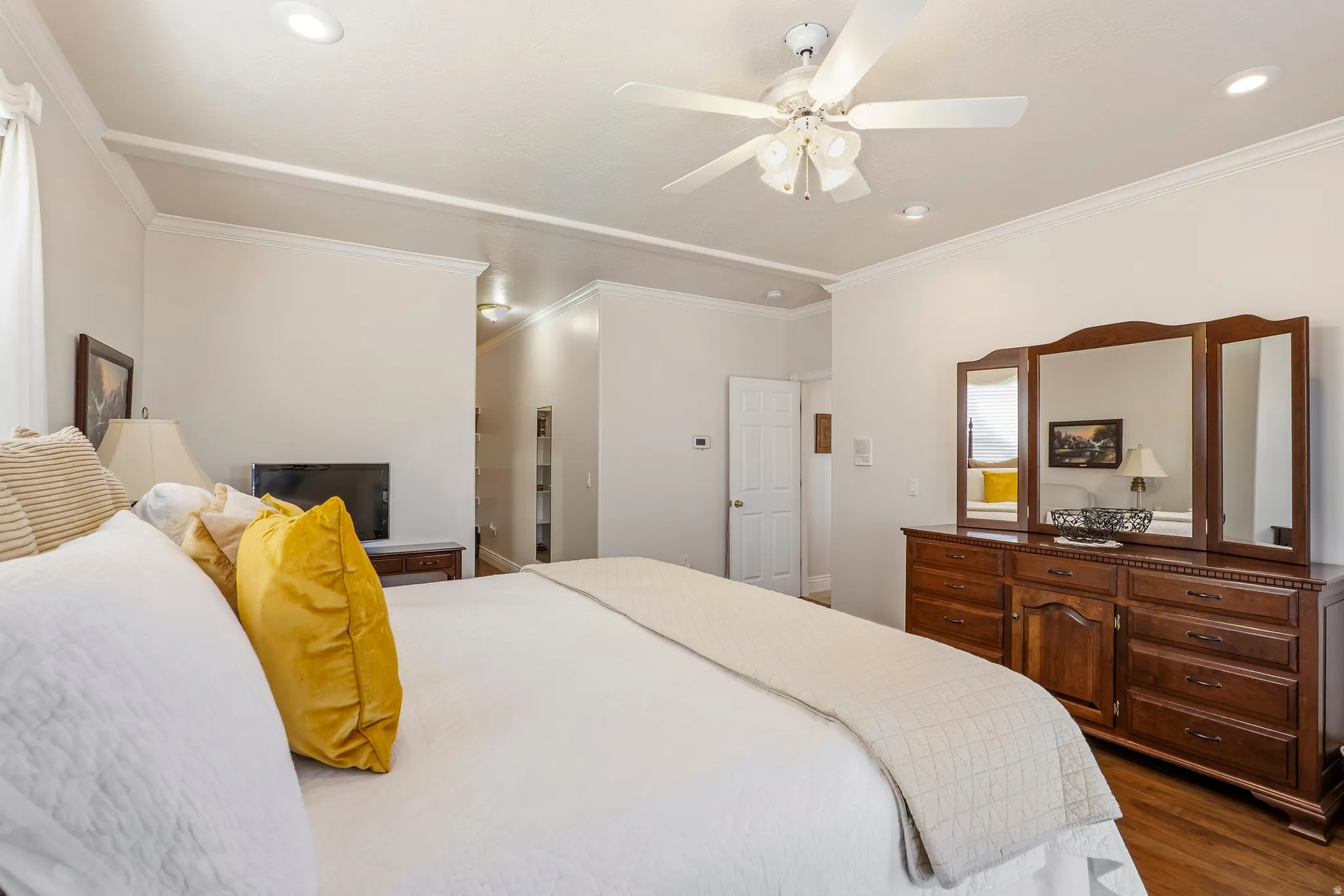 Bedroom with dark wood finished floors, crown molding, a ceiling fan, and recessed lighting