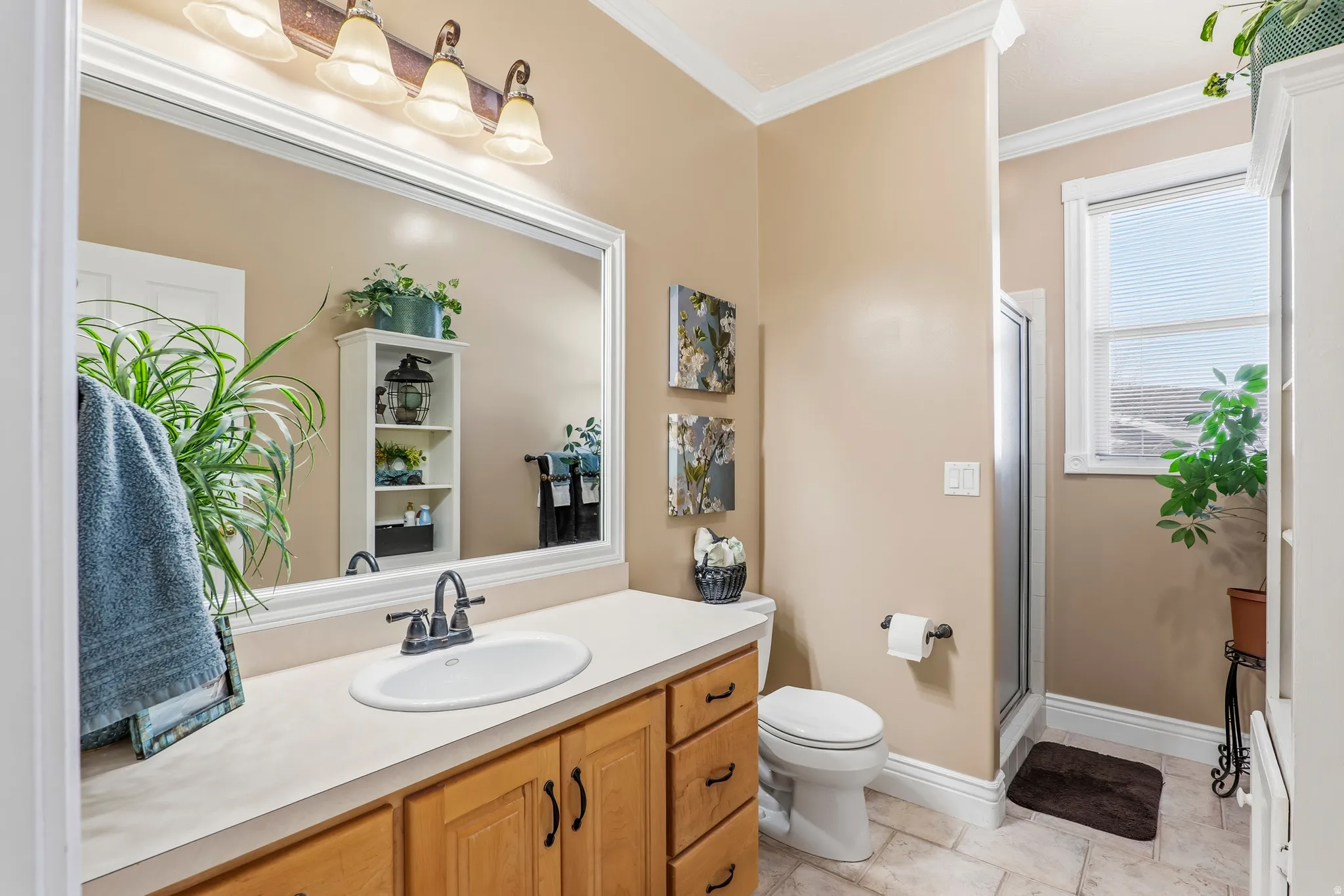 Full bath featuring vanity, a stall shower, and crown molding
