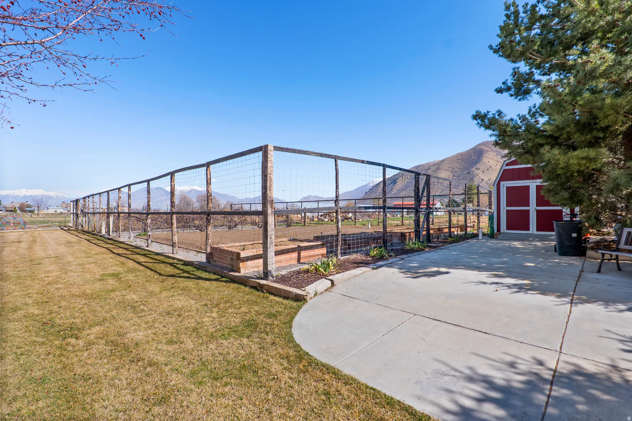 View of yard featuring a storage shed, a mountain view, and a vegetable garden