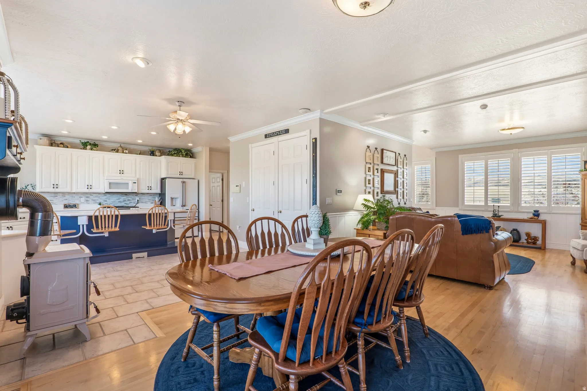 Dining area with crown molding, ceiling fan, and light wood finished floors
