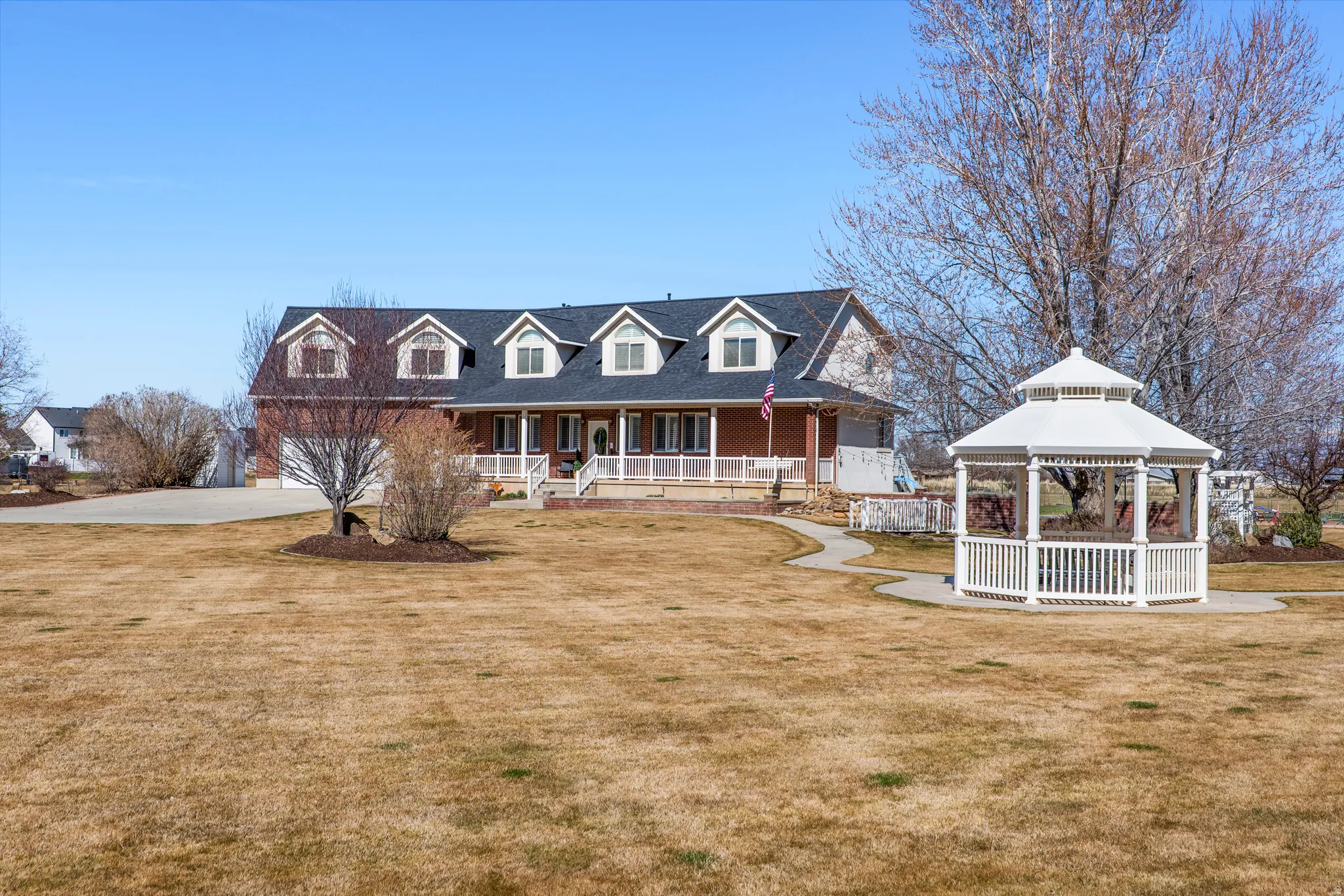View of front of home with a front yard, a porch, and concrete driveway