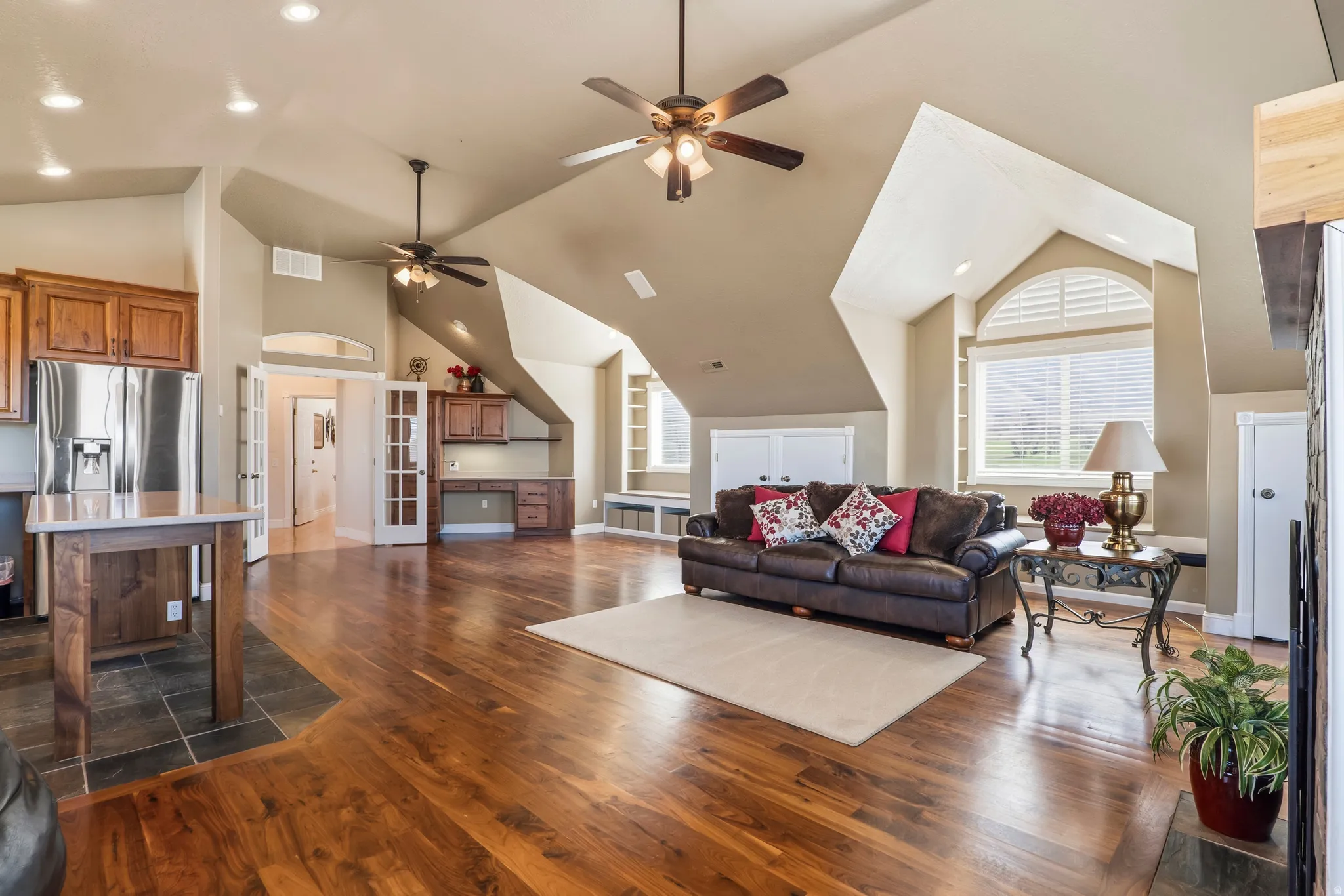 Living room featuring dark wood-style floors, recessed lighting, ceiling fan, and vaulted ceiling