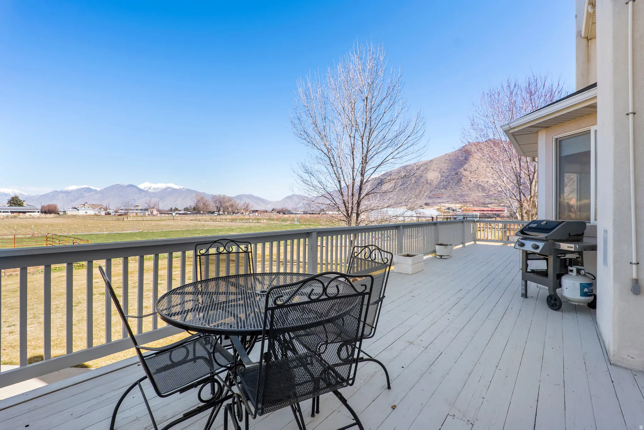 Wooden terrace featuring a mountain view, a grill, and outdoor dining space