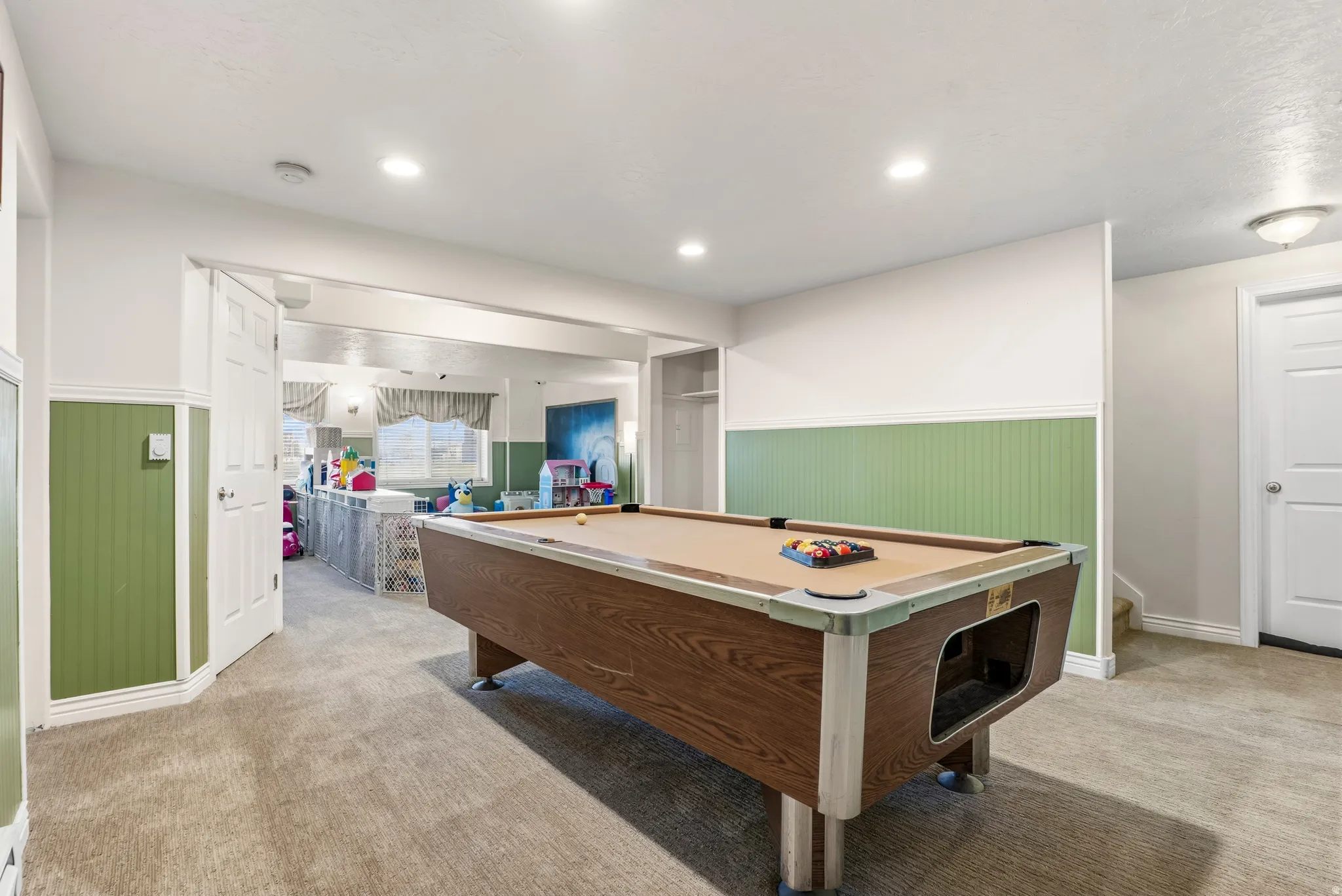 Game room with a wainscoted wall, pool table, light carpet, and recessed lighting