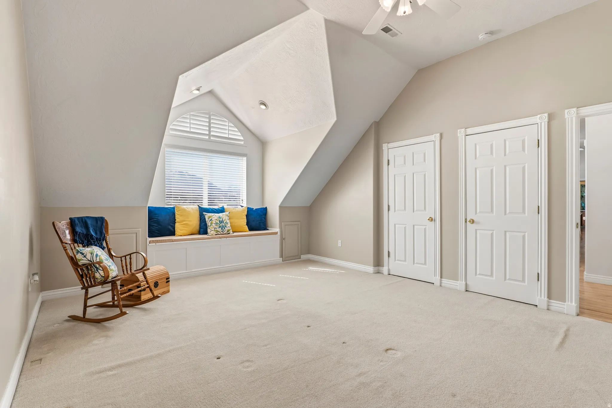 Unfurnished room featuring carpet flooring, lofted ceiling, and ceiling fan