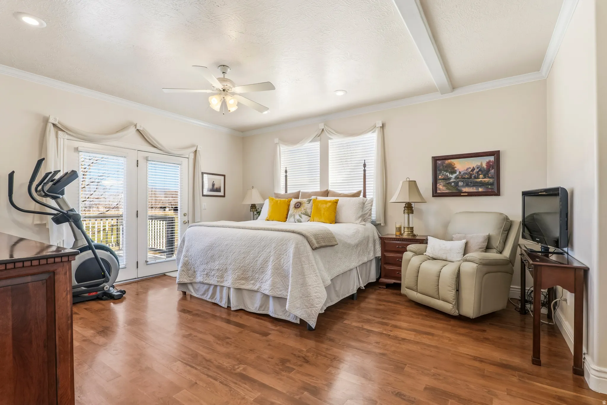 Bedroom with crown molding, access to exterior, wood finished floors, a ceiling fan, and beam ceiling