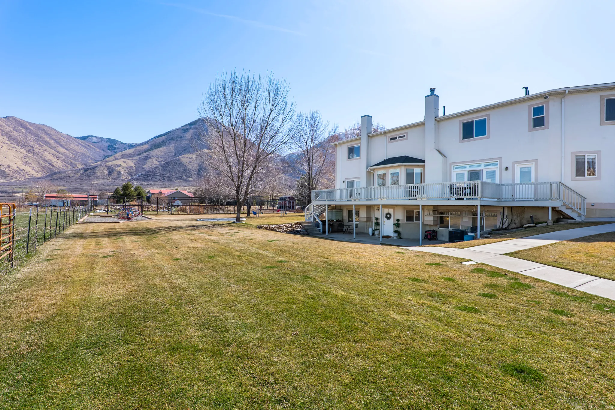 Rear view of house with a deck with mountain view, a chimney, and stucco siding