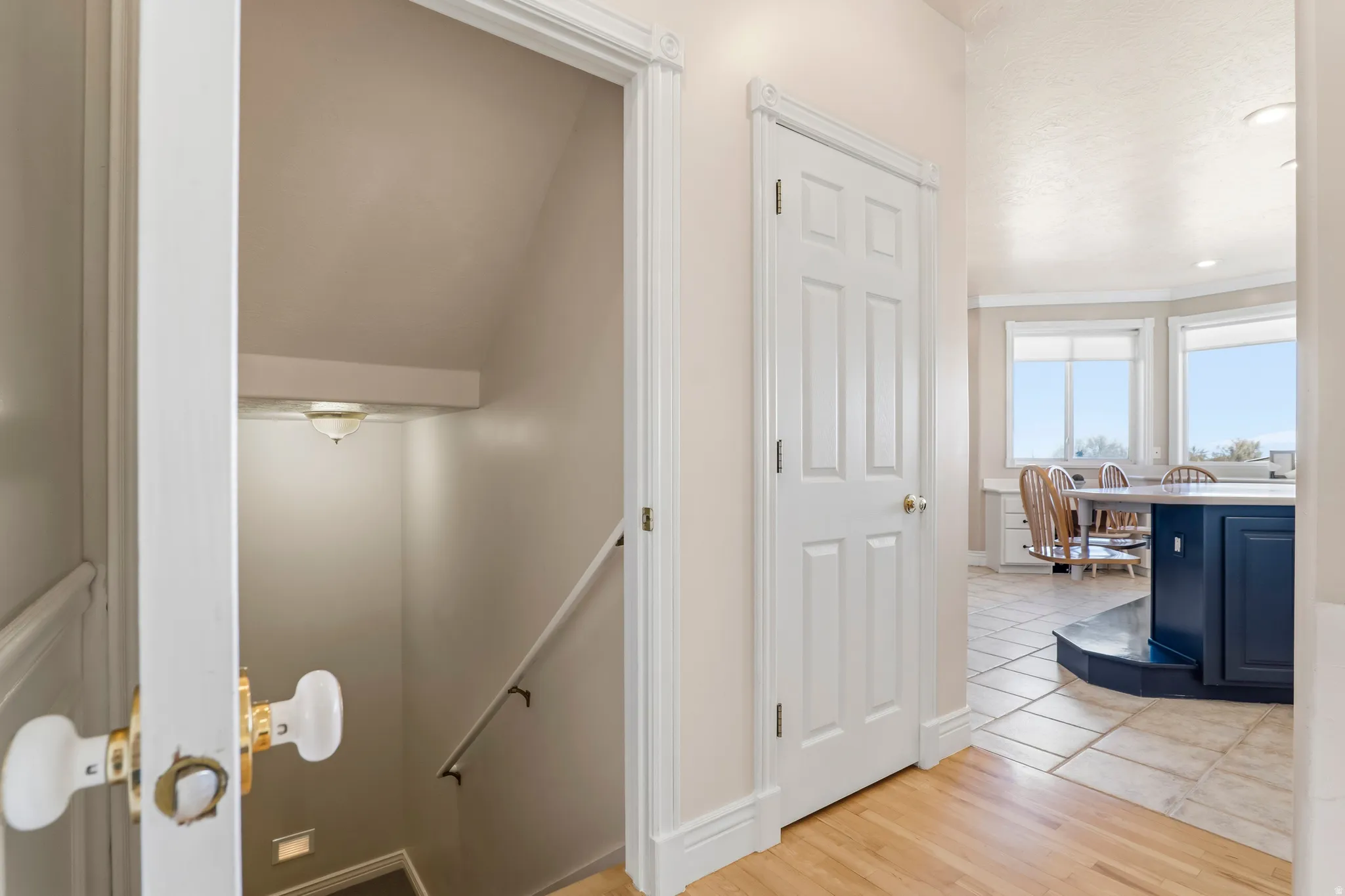 Corridor featuring light wood-style floors, recessed lighting, and an upstairs landing