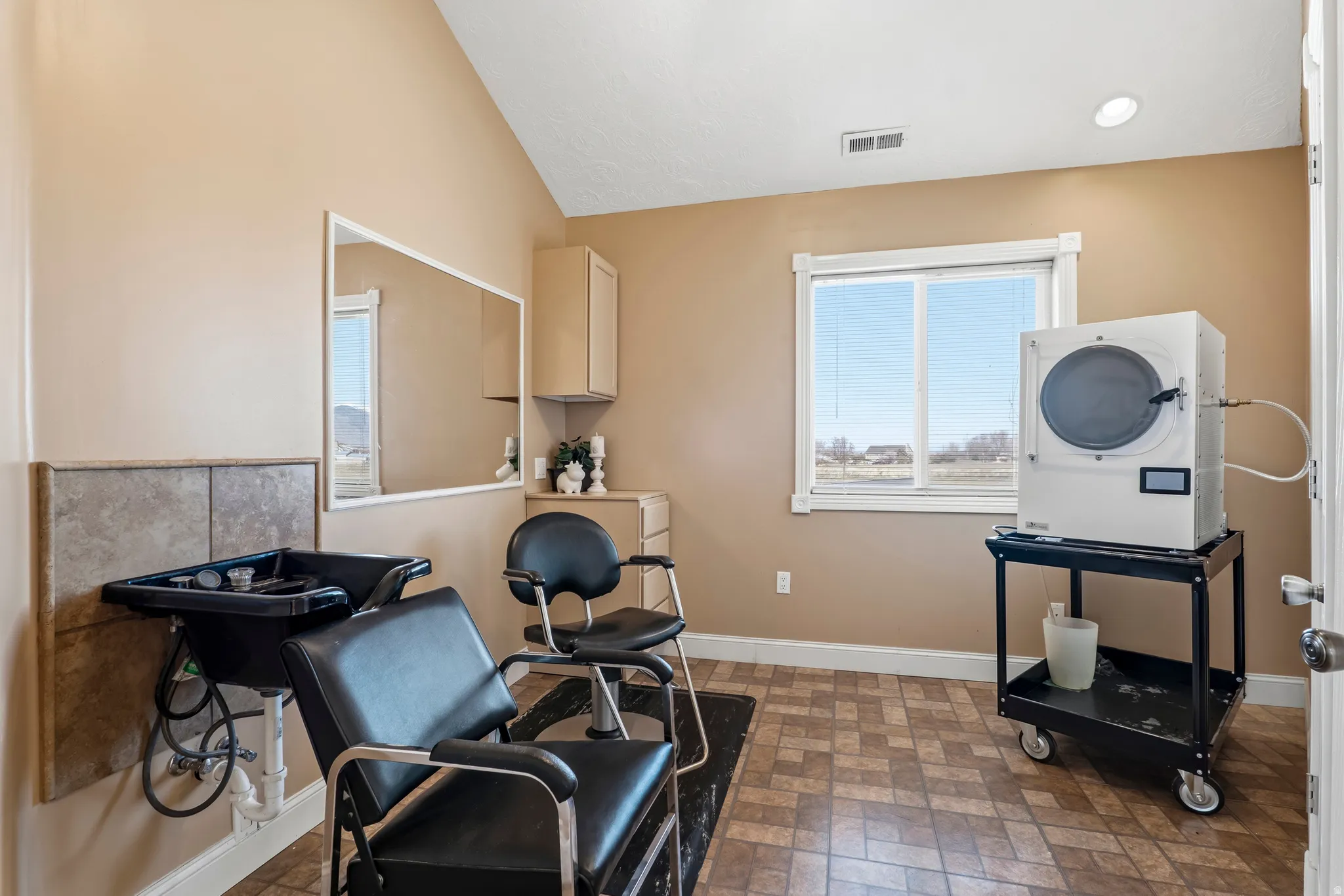 Miscellaneous room with washer / dryer, brick patterned floors, and vaulted ceiling