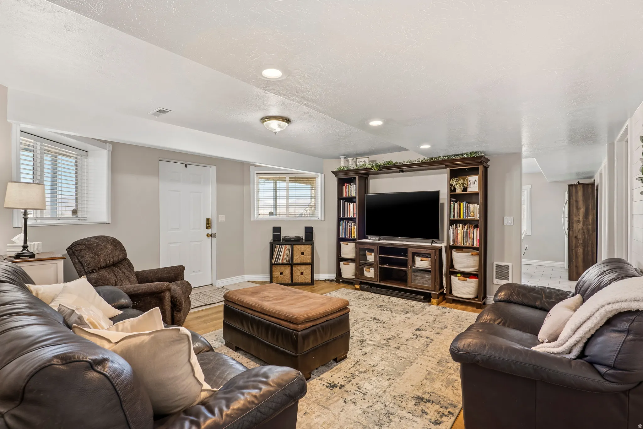 Living room with wood finished floors, plenty of natural light, recessed lighting, and a textured ceiling