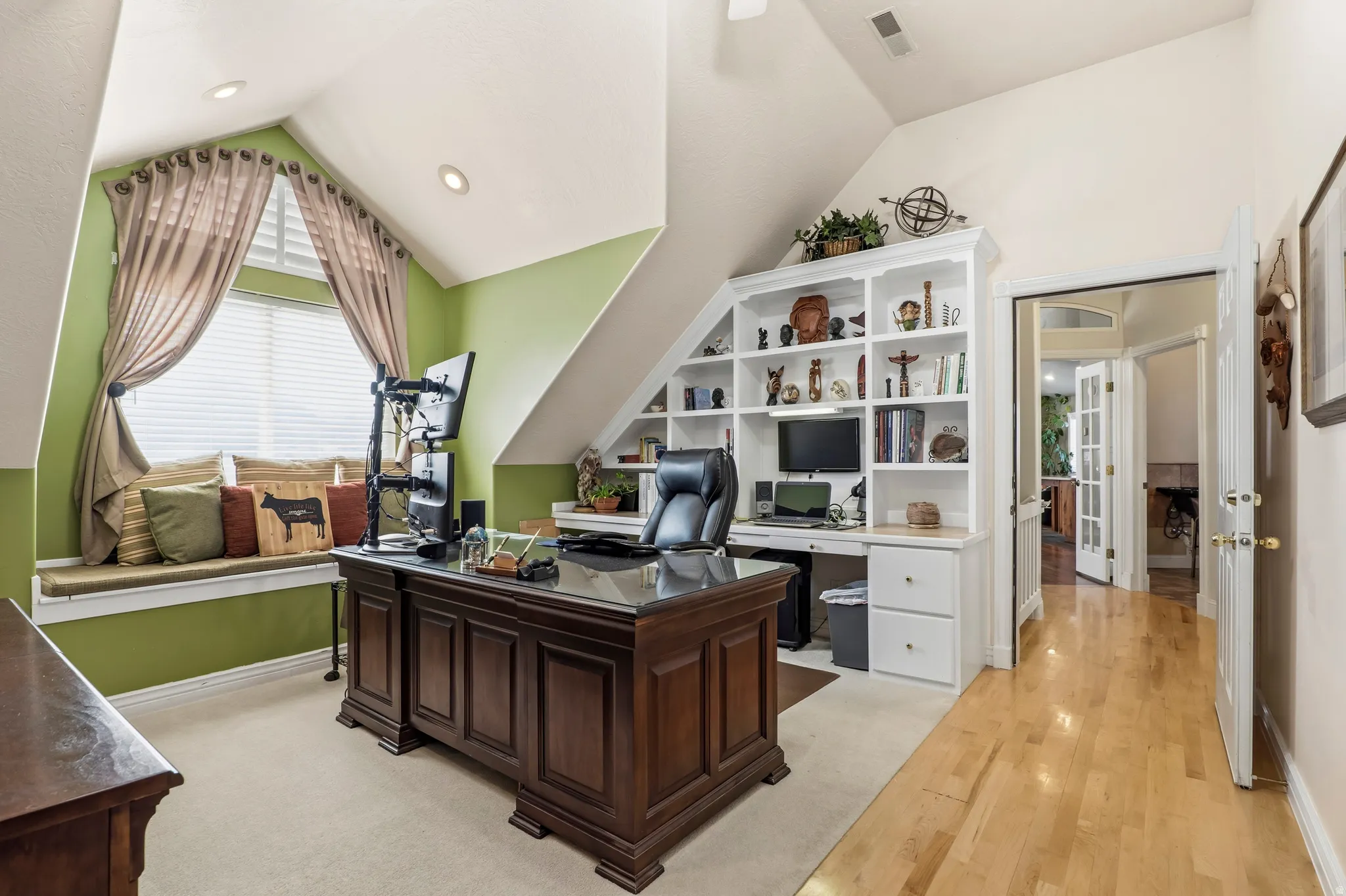 Home office with vaulted ceiling and light wood-style floors