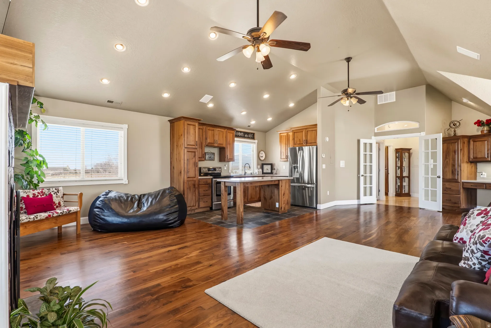 Living area with dark wood finished floors, french doors, vaulted ceiling, ceiling fan, and recessed lighting