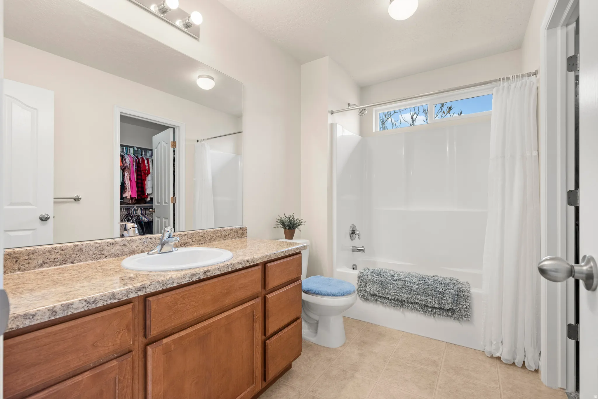 Full bathroom with vanity, shower / tub combo with curtain, and a spacious closet