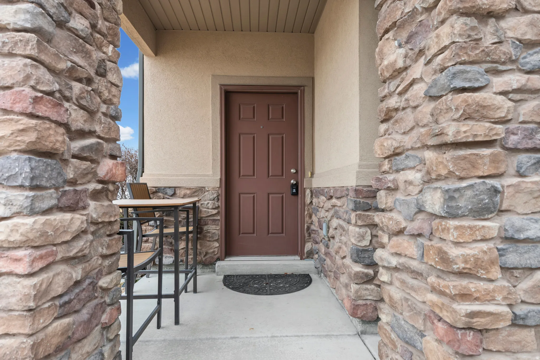 Property entrance featuring stone siding and stucco siding