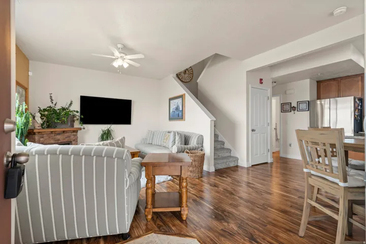 Living area featuring dark wood-style flooring, a ceiling fan, and a textured ceiling