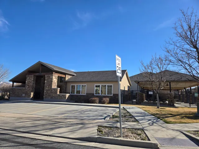 View of front facade featuring stone siding and uncovered parking