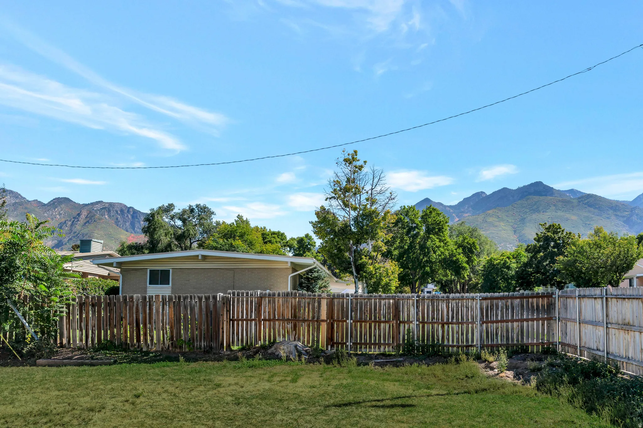 Fenced backyard featuring a mountain view
