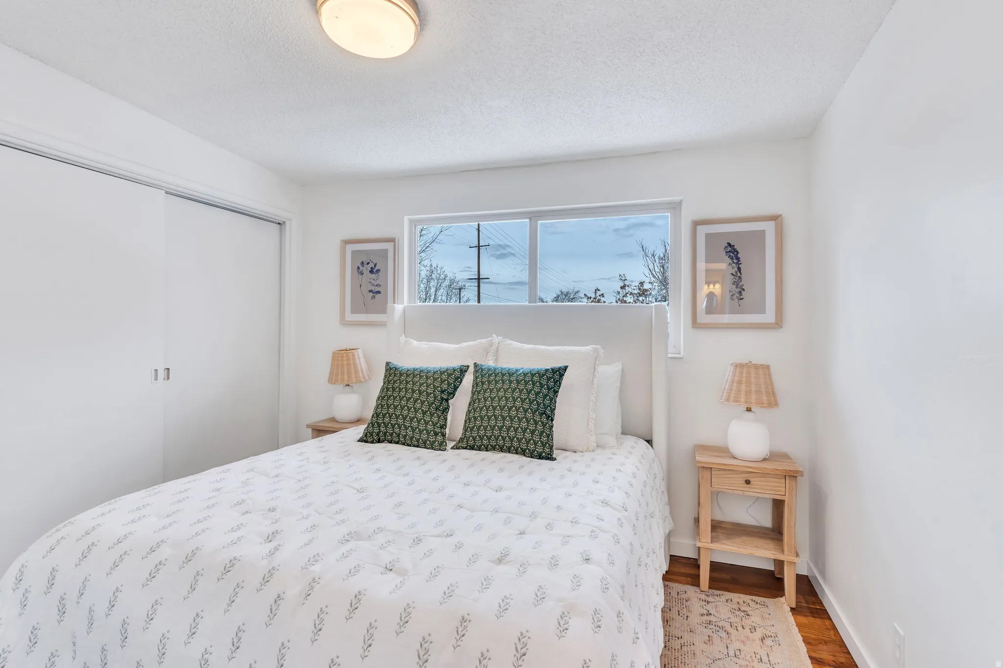 Bedroom featuring a closet, wood finished floors, and a textured ceiling