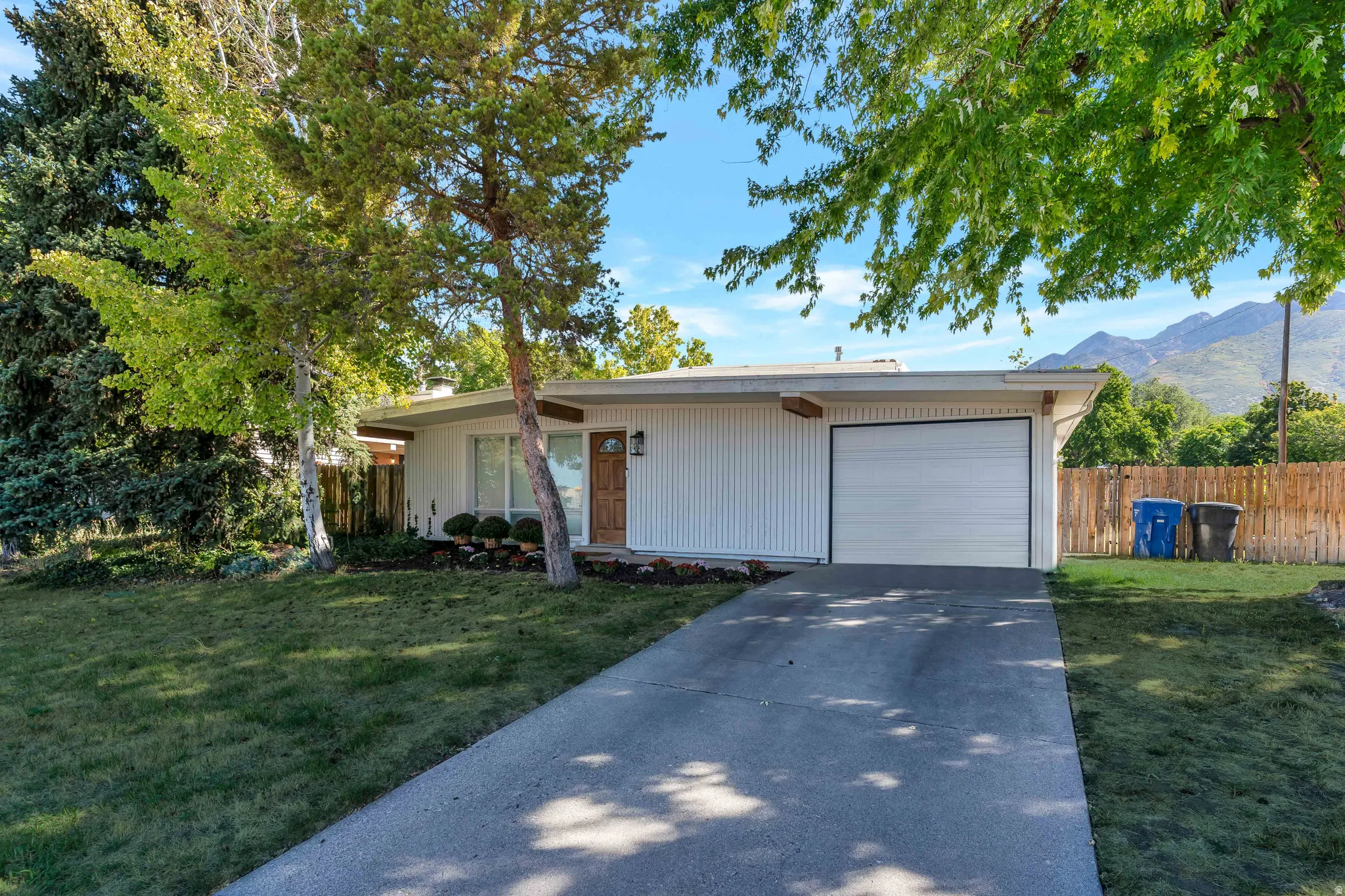 View of front facade featuring a garage, concrete driveway, and a mountain view