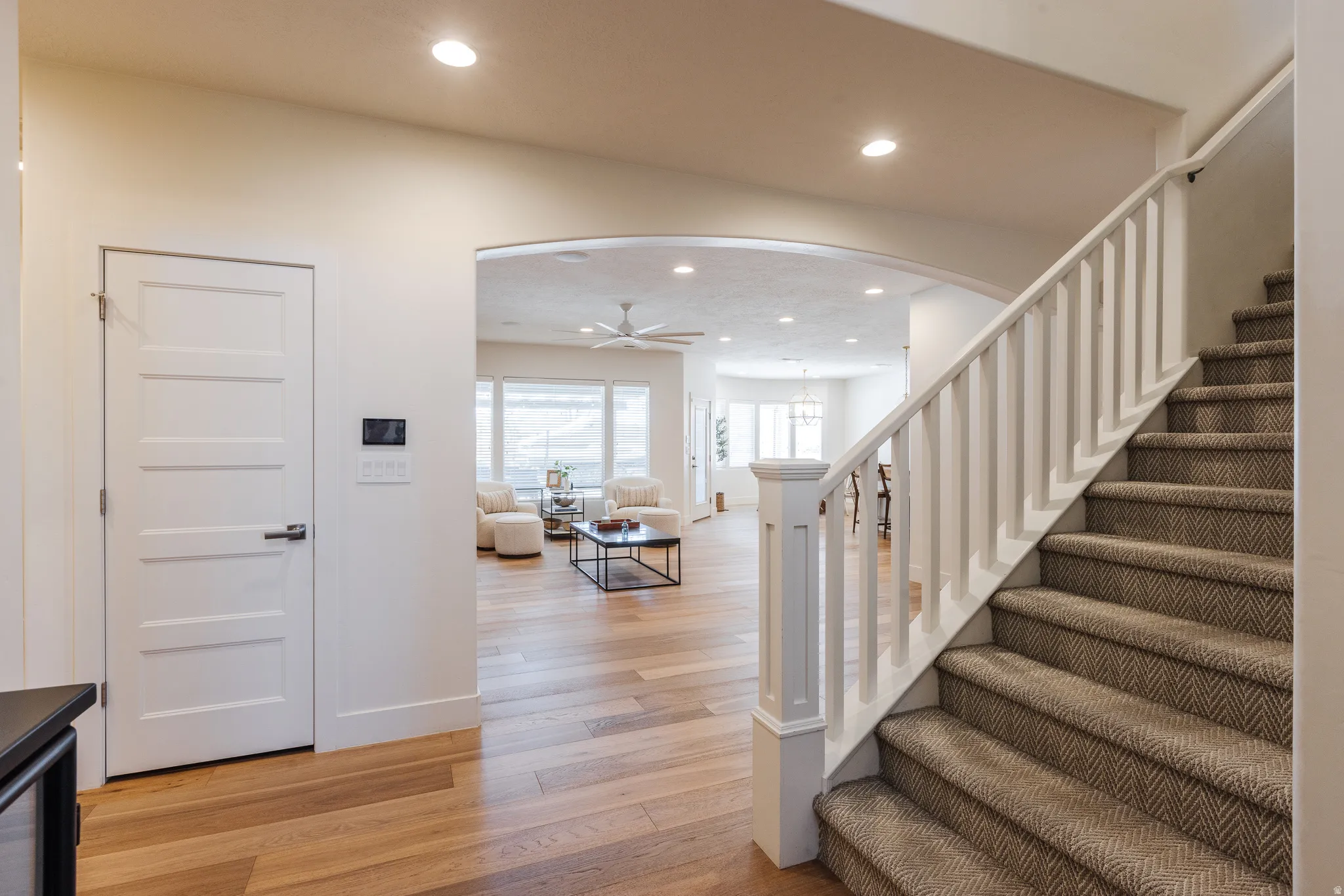 Staircase featuring arched walkways, recessed lighting, wood finished floors, and ceiling fan