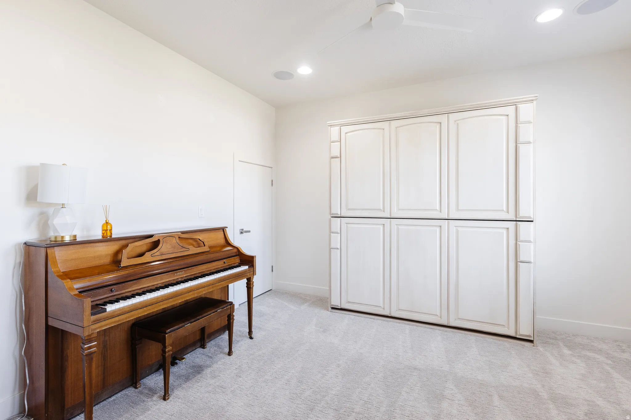 Living area with a ceiling fan, light carpet, and recessed lighting