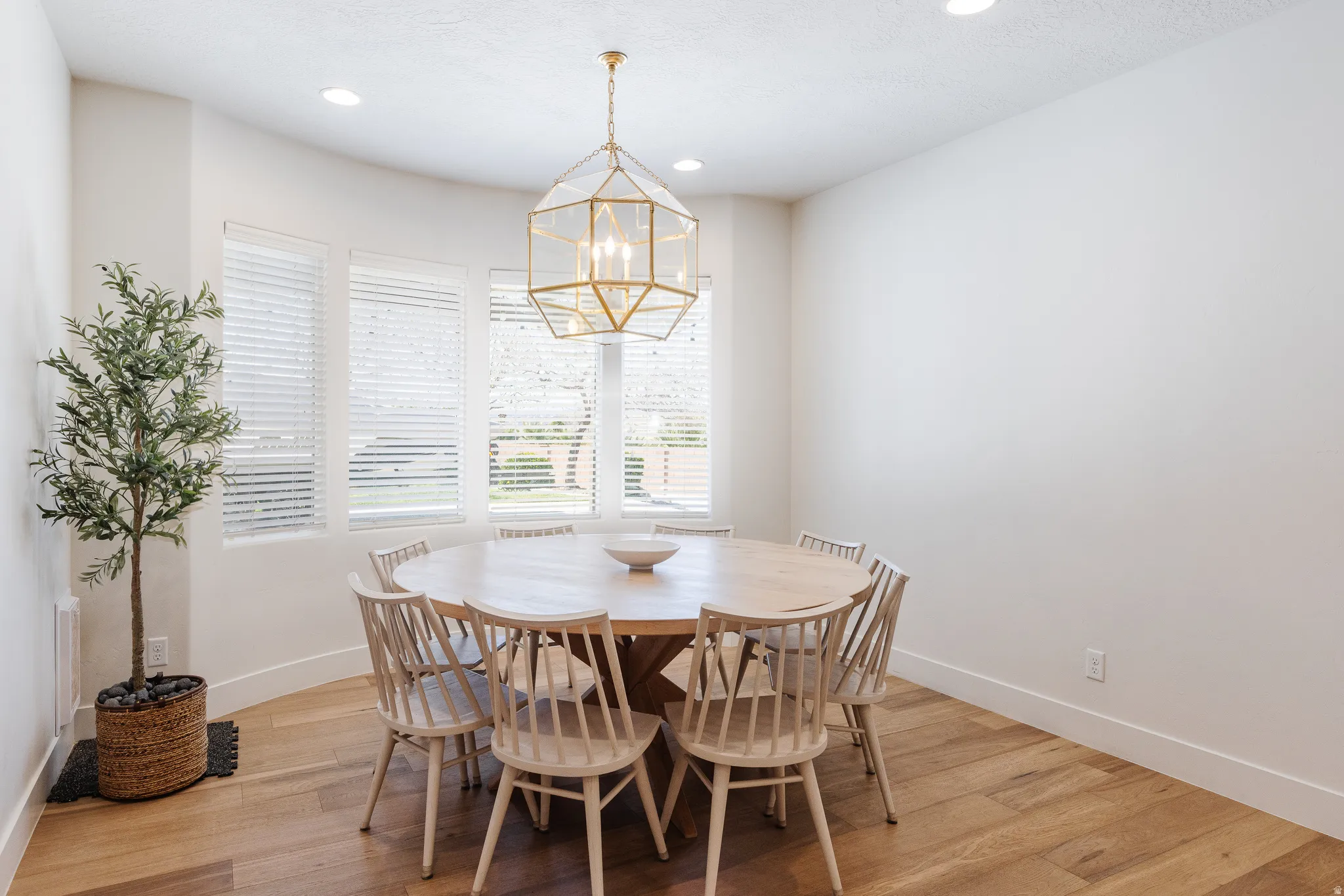 Dining area with light wood-type flooring and hanging lights