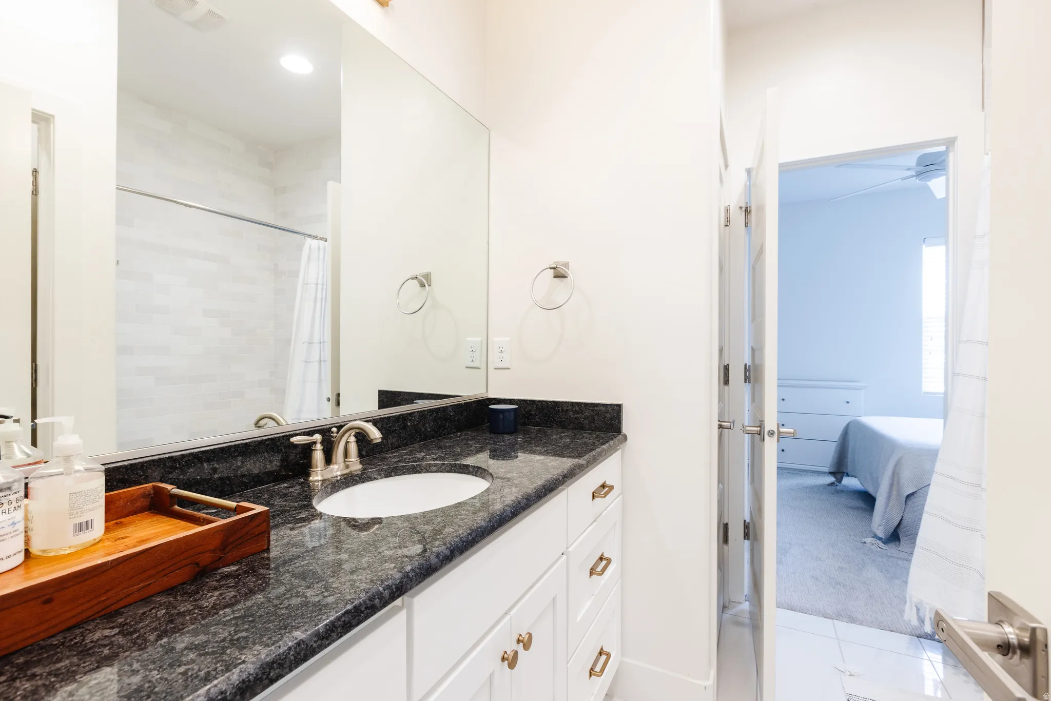Full bathroom featuring ensuite bathroom, vanity, a shower with shower curtain, and light colored carpet