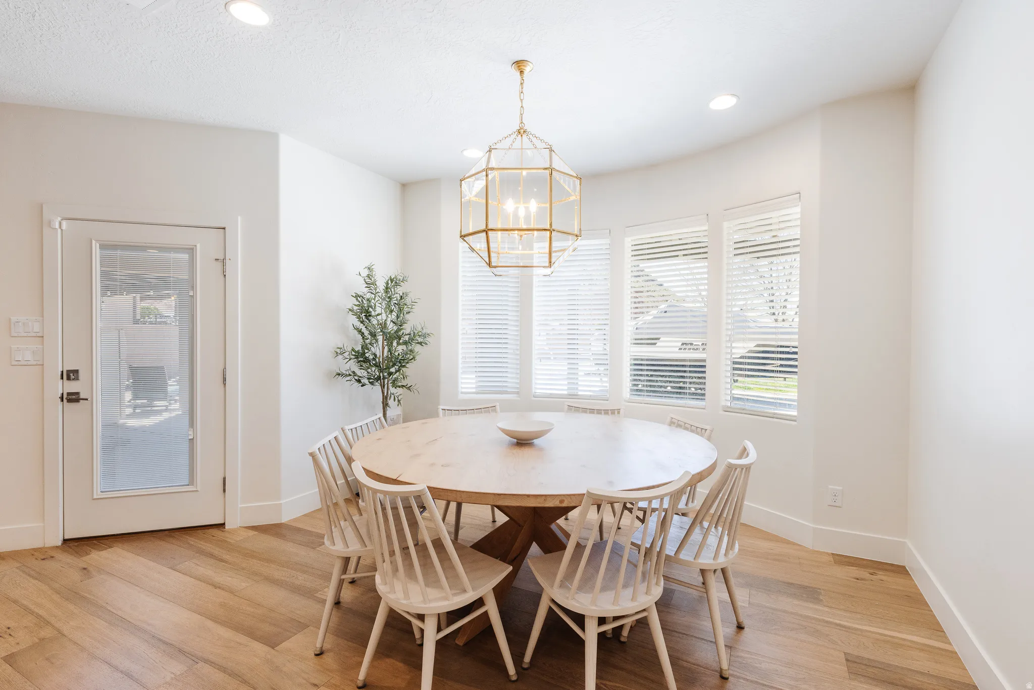 Dining area with light wood finished floors and hanging lights