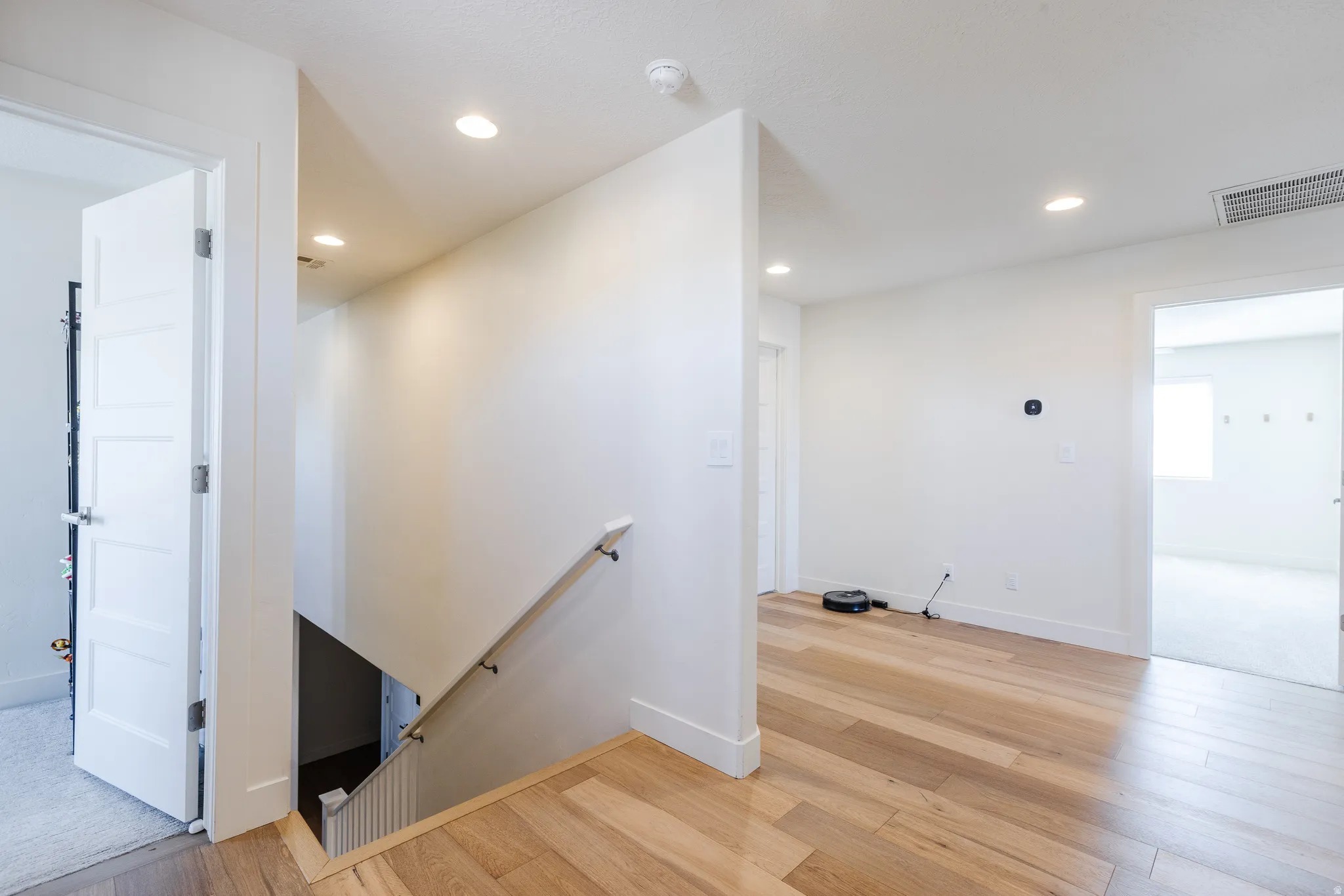 Stairway featuring wood finished floors and recessed lighting