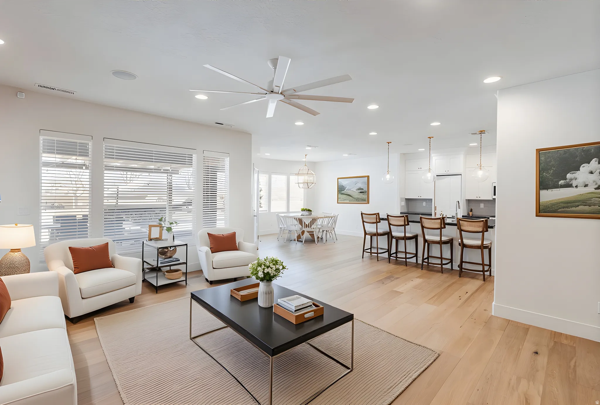 Living area featuring light wood-style floors, a ceiling fan, and recessed lighting