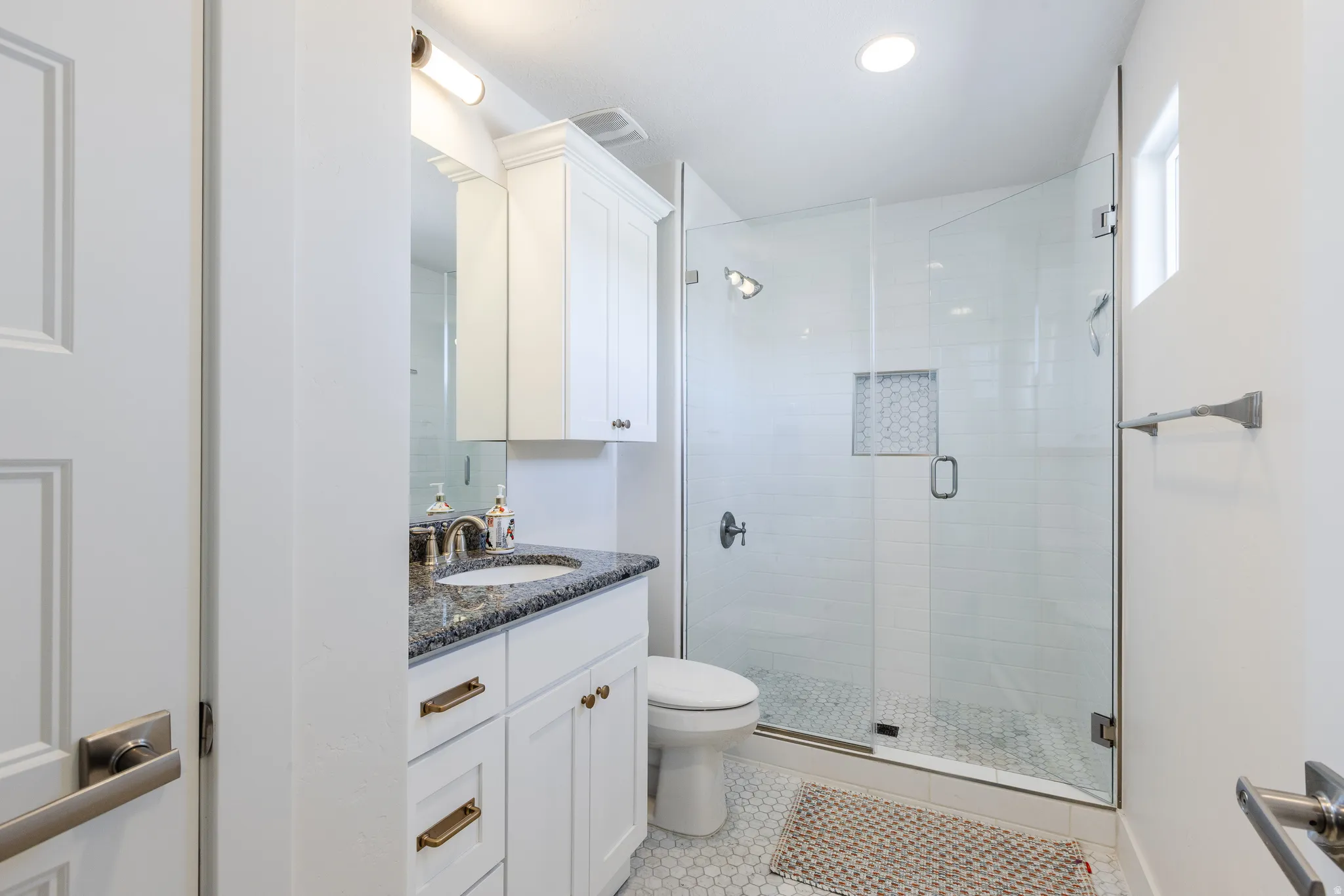 Bathroom with vanity, a shower stall, light tile patterned floors, and recessed lighting