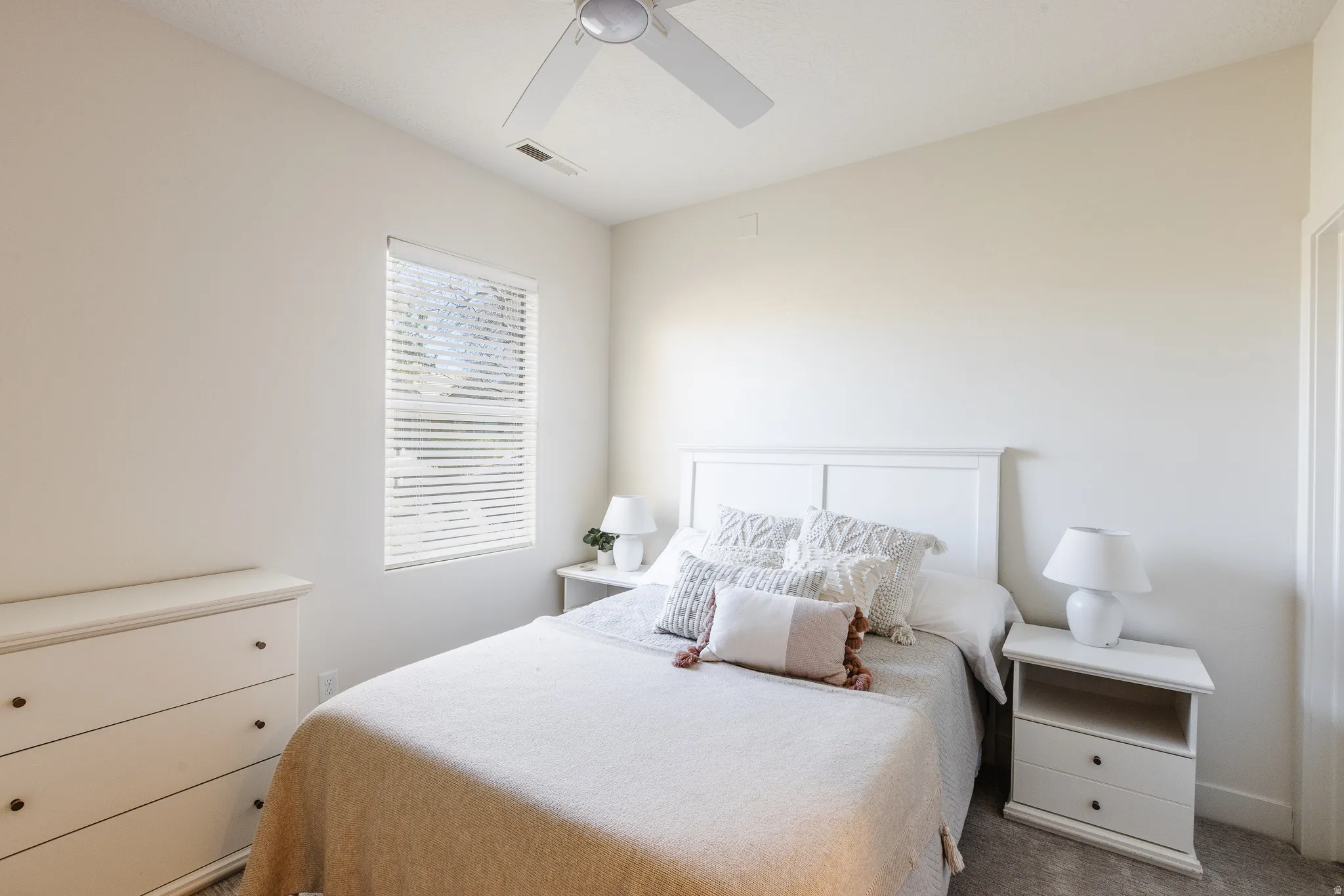 Carpeted bedroom featuring a ceiling fan
