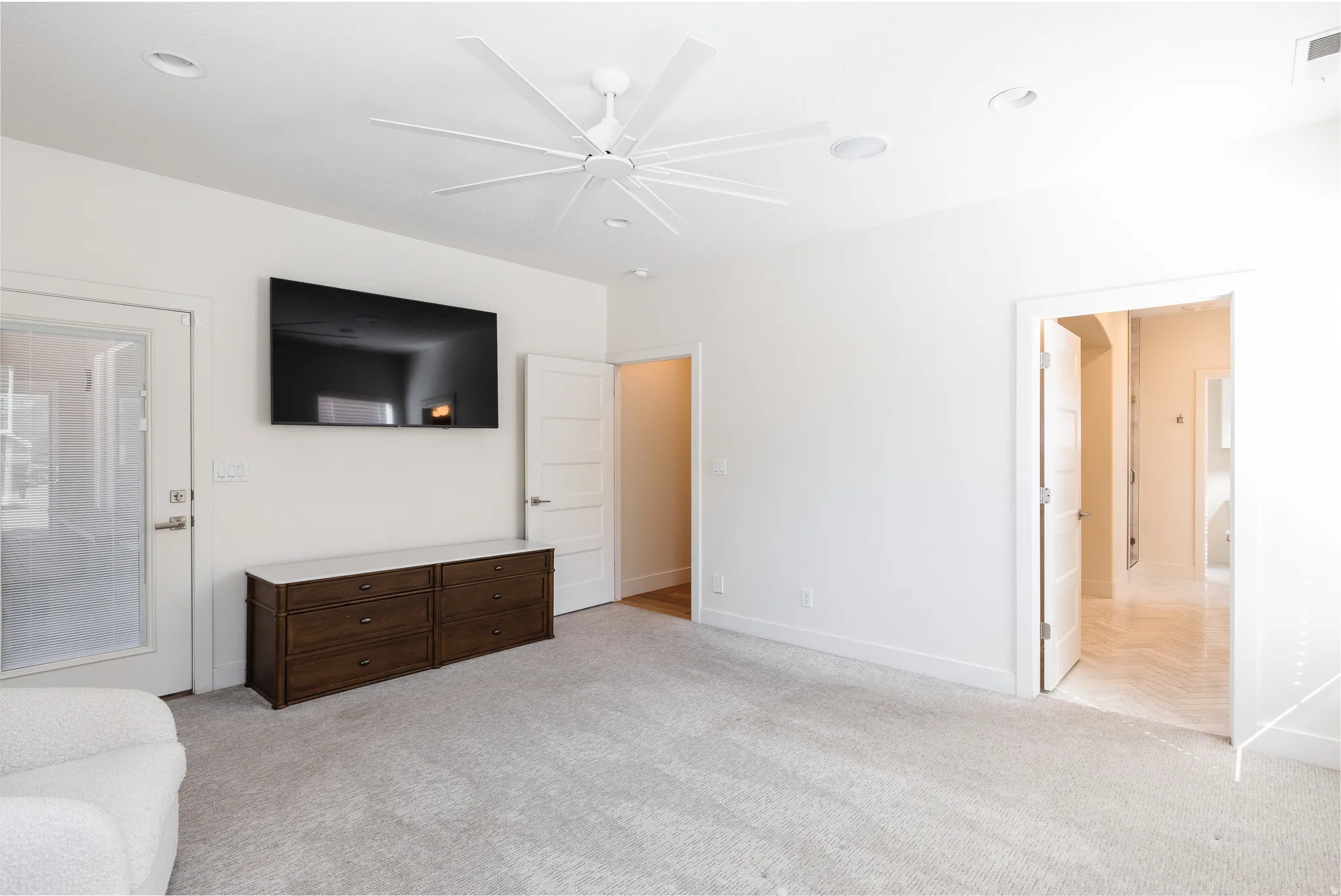 Unfurnished living room featuring light carpet and ceiling fan