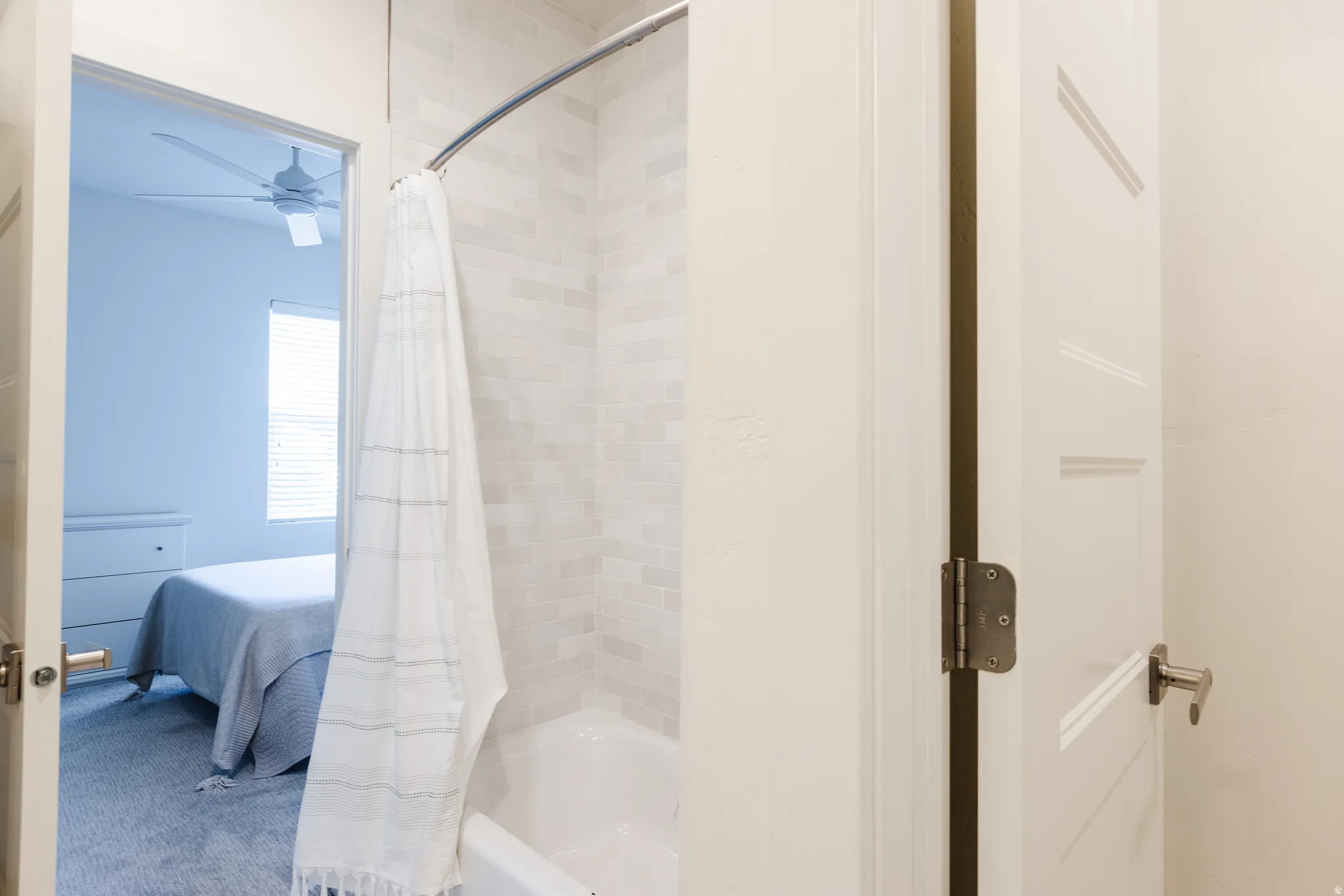 Ensuite bathroom with shower / bath combo and ceiling fan