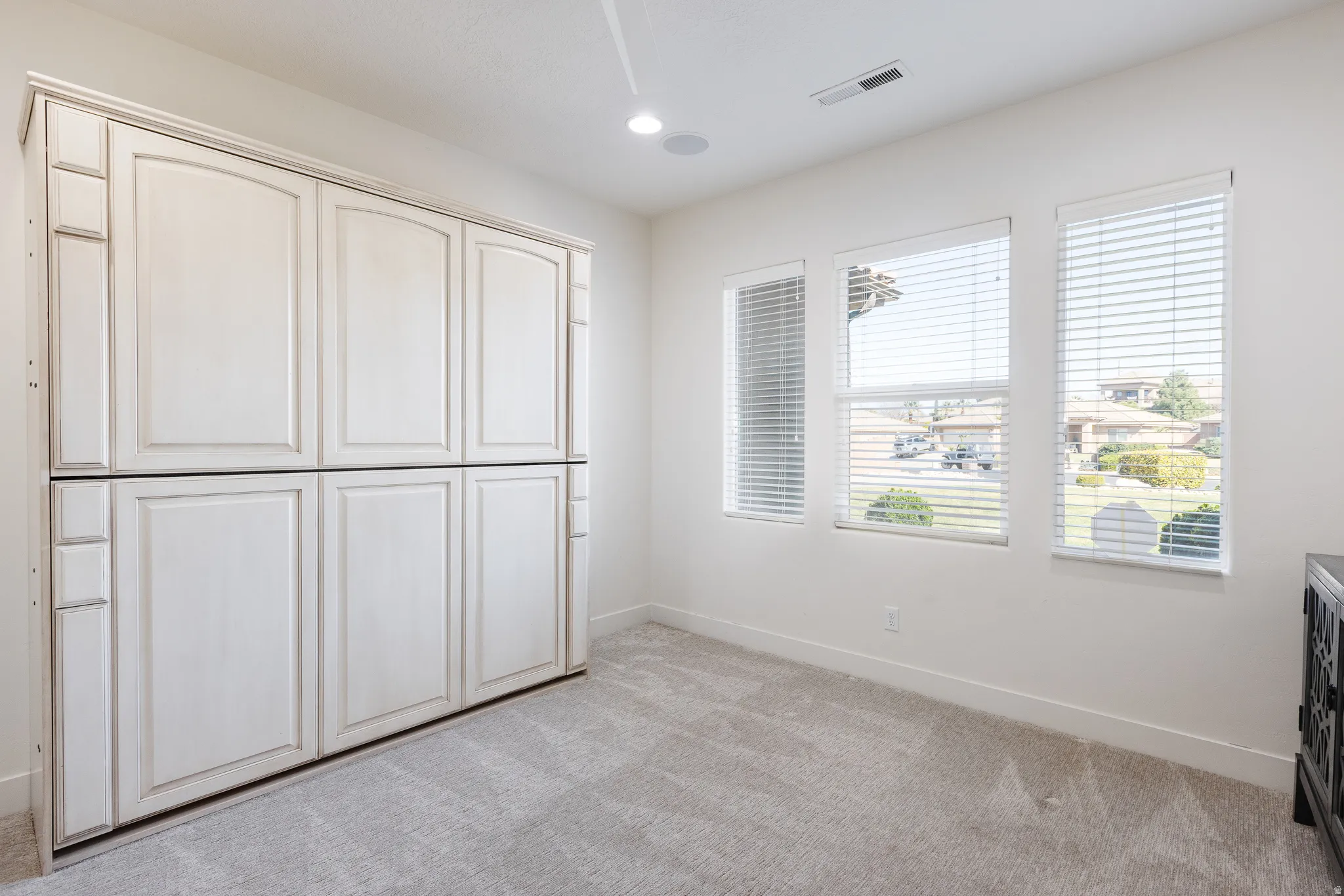 Unfurnished bedroom with light carpet, a closet, and recessed lighting