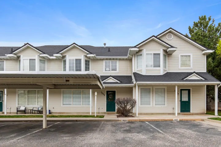 View of front facade with covered porch, a shingled roof, and uncovered parking