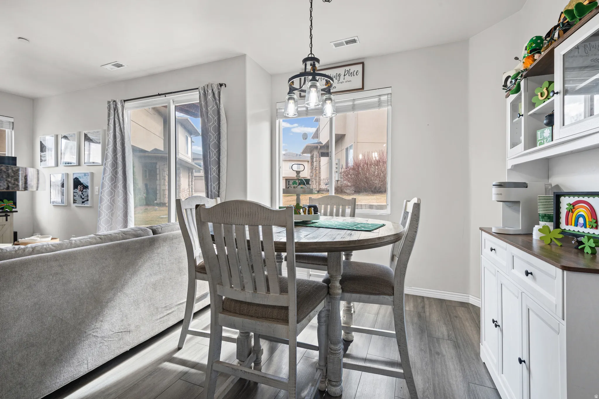 Dining space featuring dark wood finished floors, healthy amount of natural light, and hanging lights
