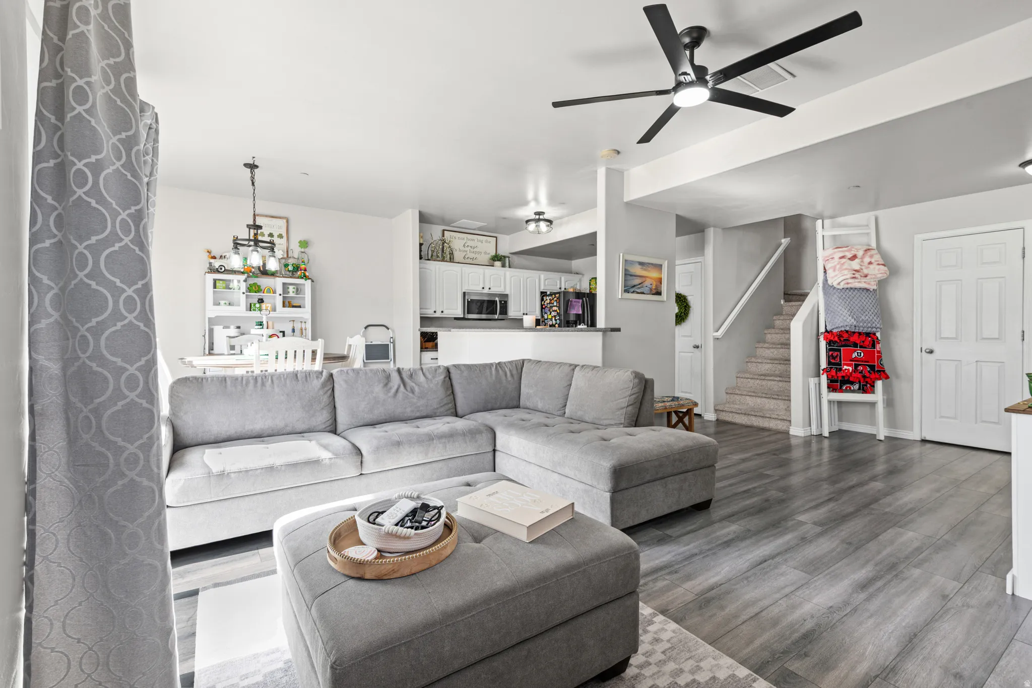 Living area featuring ceiling fan and dark wood finished floors