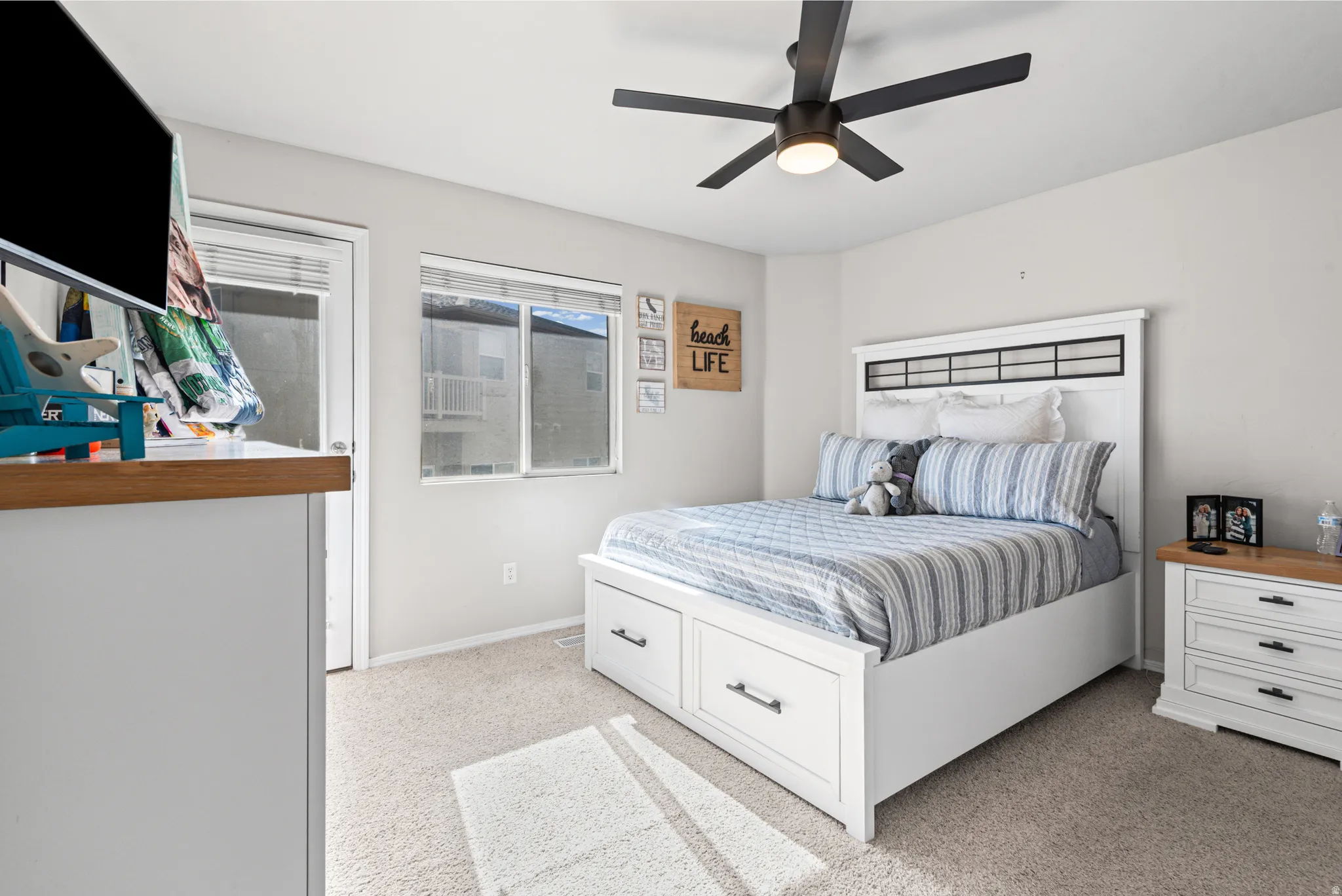 Bedroom with light carpet and a ceiling fan
