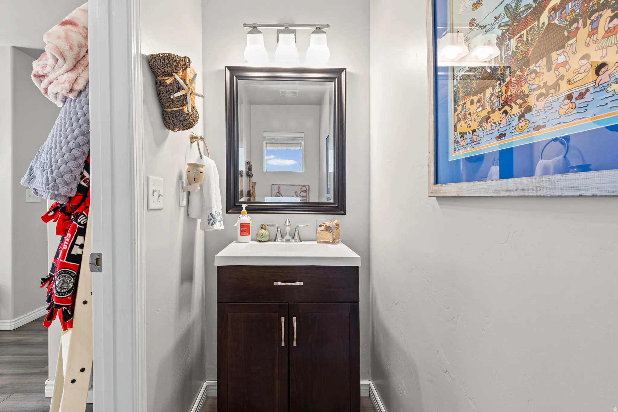Half bathroom featuring vanity and dark wood finished floors