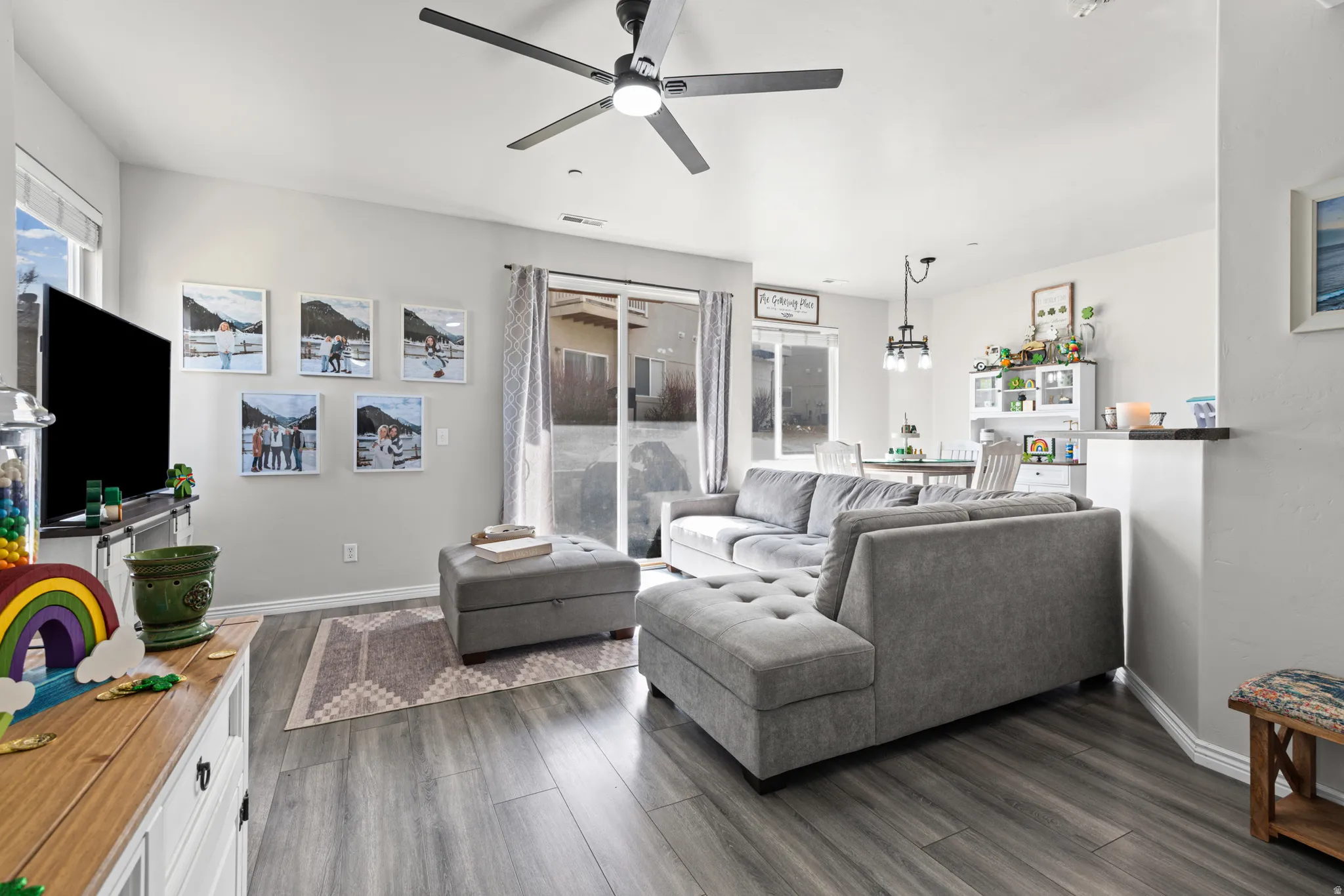 Living area with dark wood finished floors and a ceiling fan