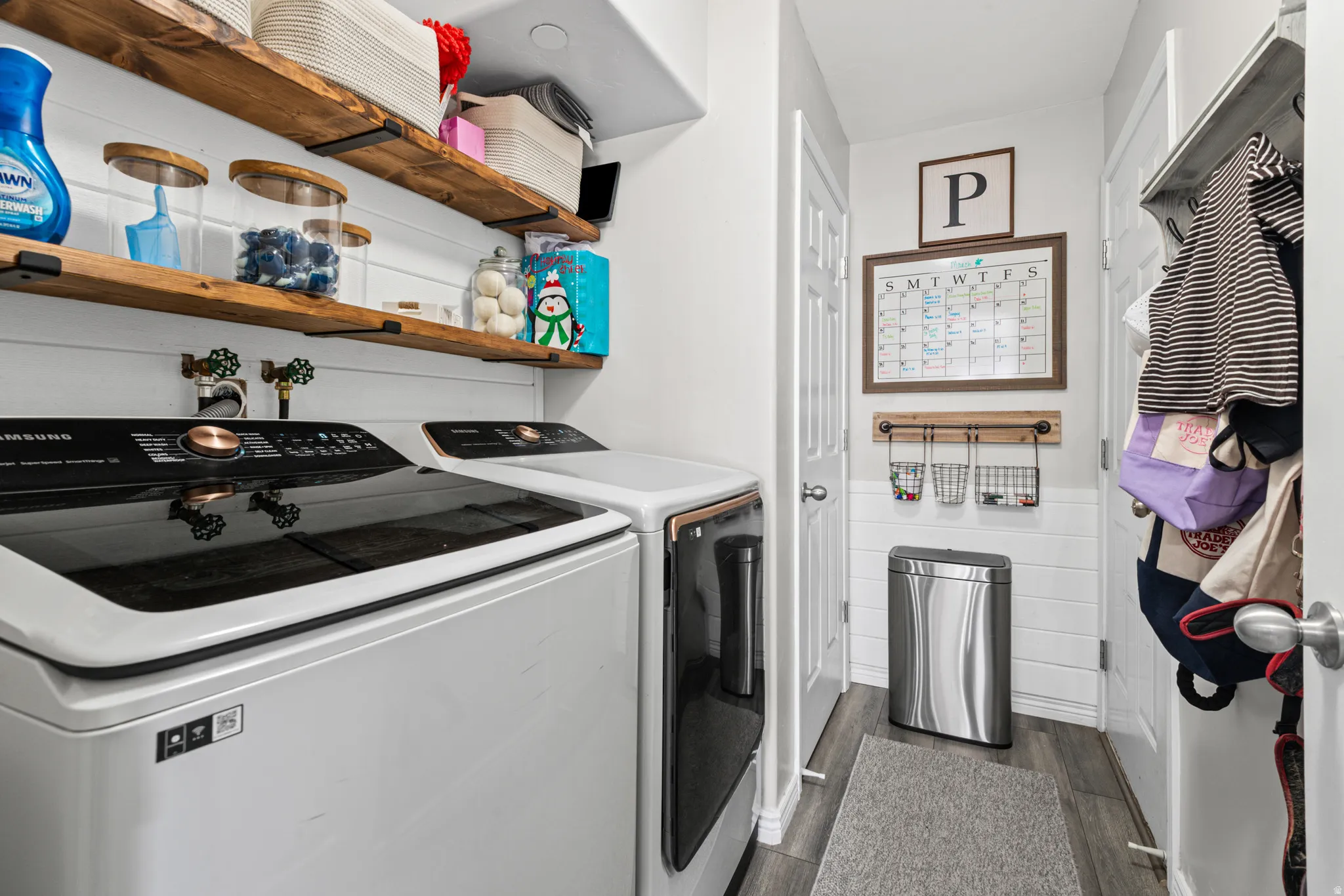 Laundry area with dark wood-style floors and independent washer and dryer