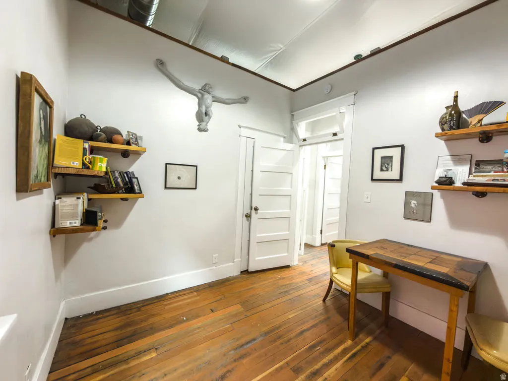 Office area featuring dark wood-type flooring and baseboards