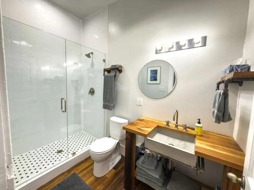 Bathroom featuring a shower stall, dark wood-style floors, and vanity
