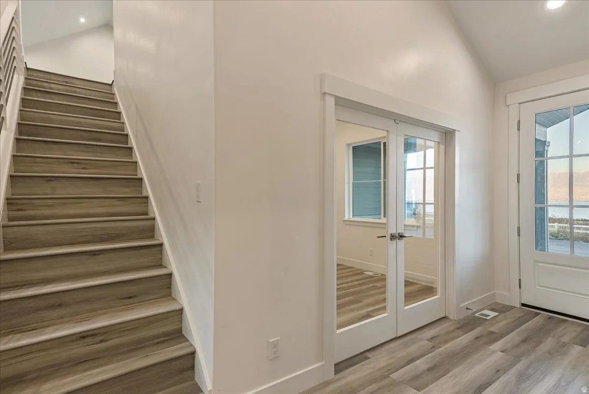 Stairway featuring french doors, recessed lighting, and wood finished floors