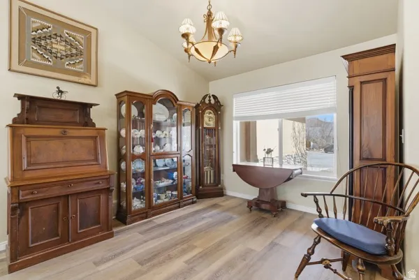 Sitting room featuring hanging lights, light wood finished floors, and vaulted ceiling