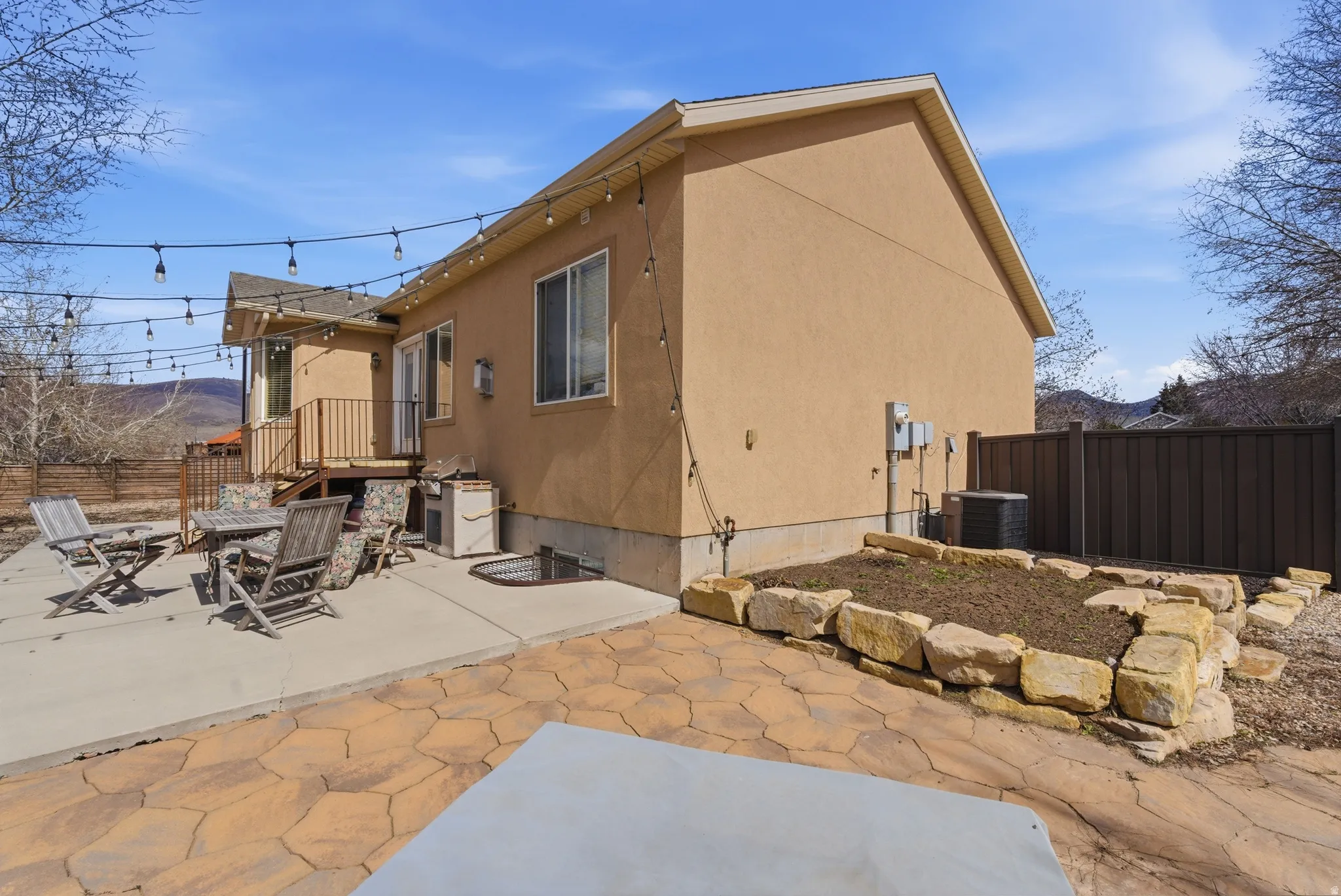 Expansive patio space featuring a concrete slab and flagstone-style paving