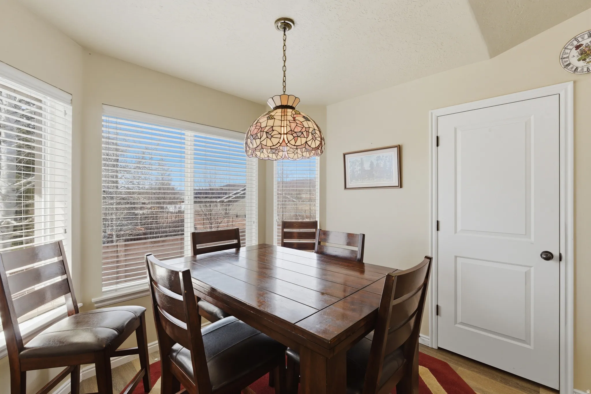 Dining area featuring a bay window with horizontal blinds- pantry door